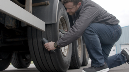 Transense Technologies managing director Ryan Maughan inspects a truck trailer tire with TLGX4.